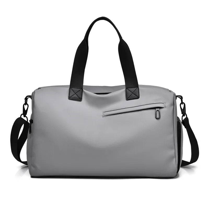 Gray minimalist duffel bag with black handles and shoulder strap, designed for commuters and travelers